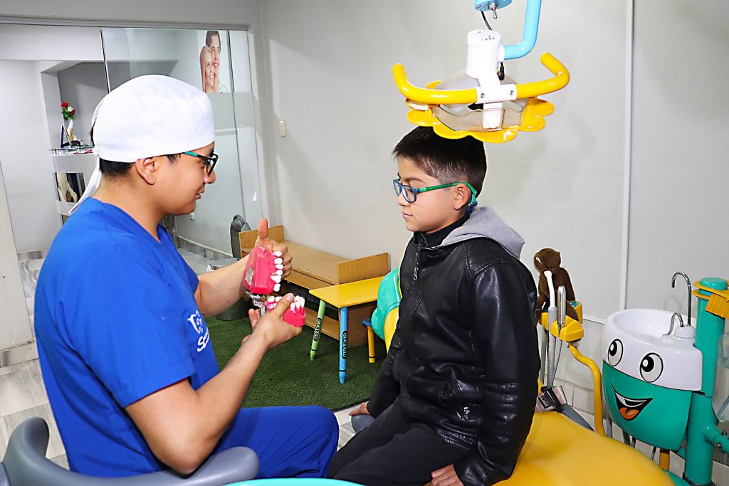 Doctor de odontopediatria explica a un niño en Juliaca